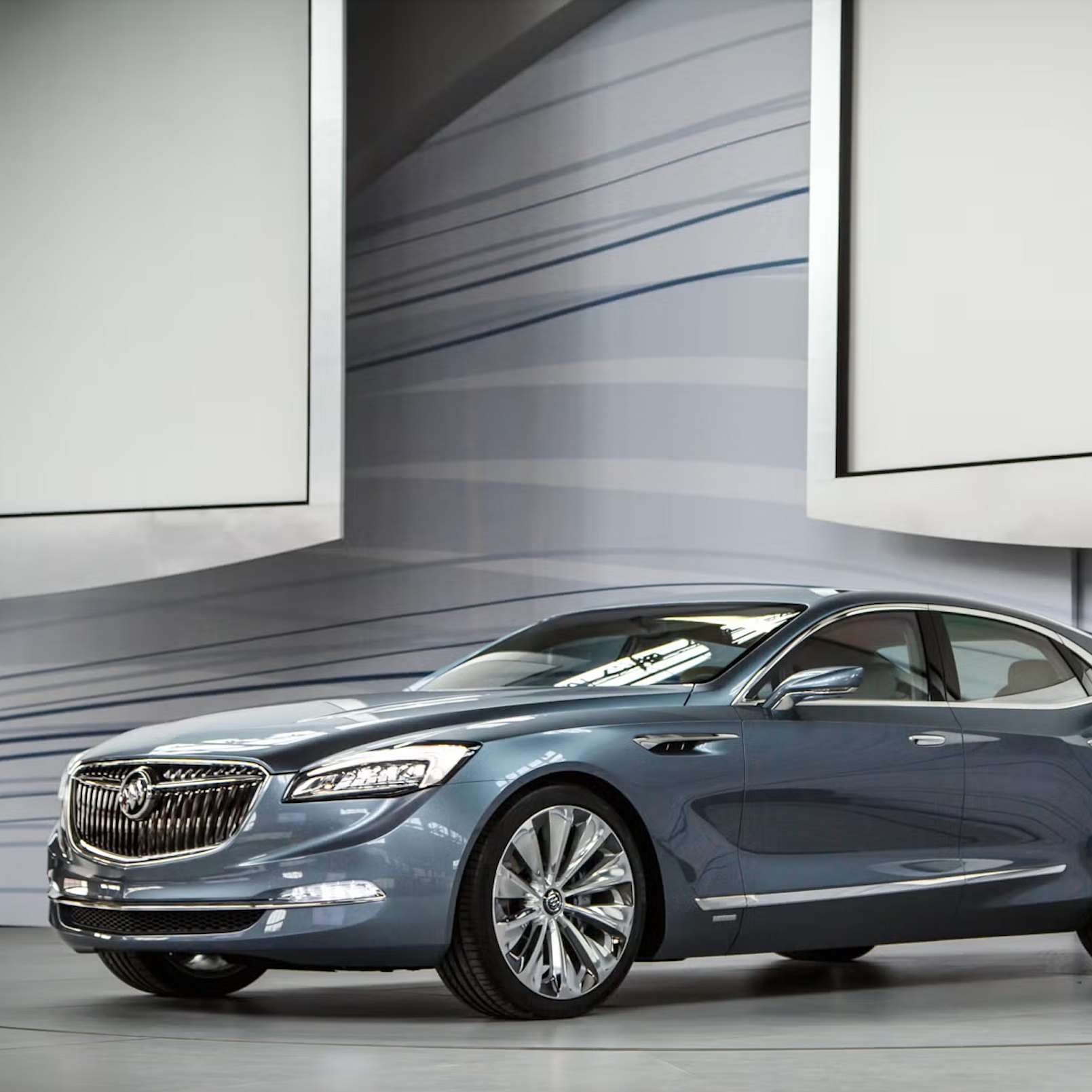 The Buick Avenir Concept on the NAIAS show floor, wave linework sweeping across the booth walls, vehicle design by Buick