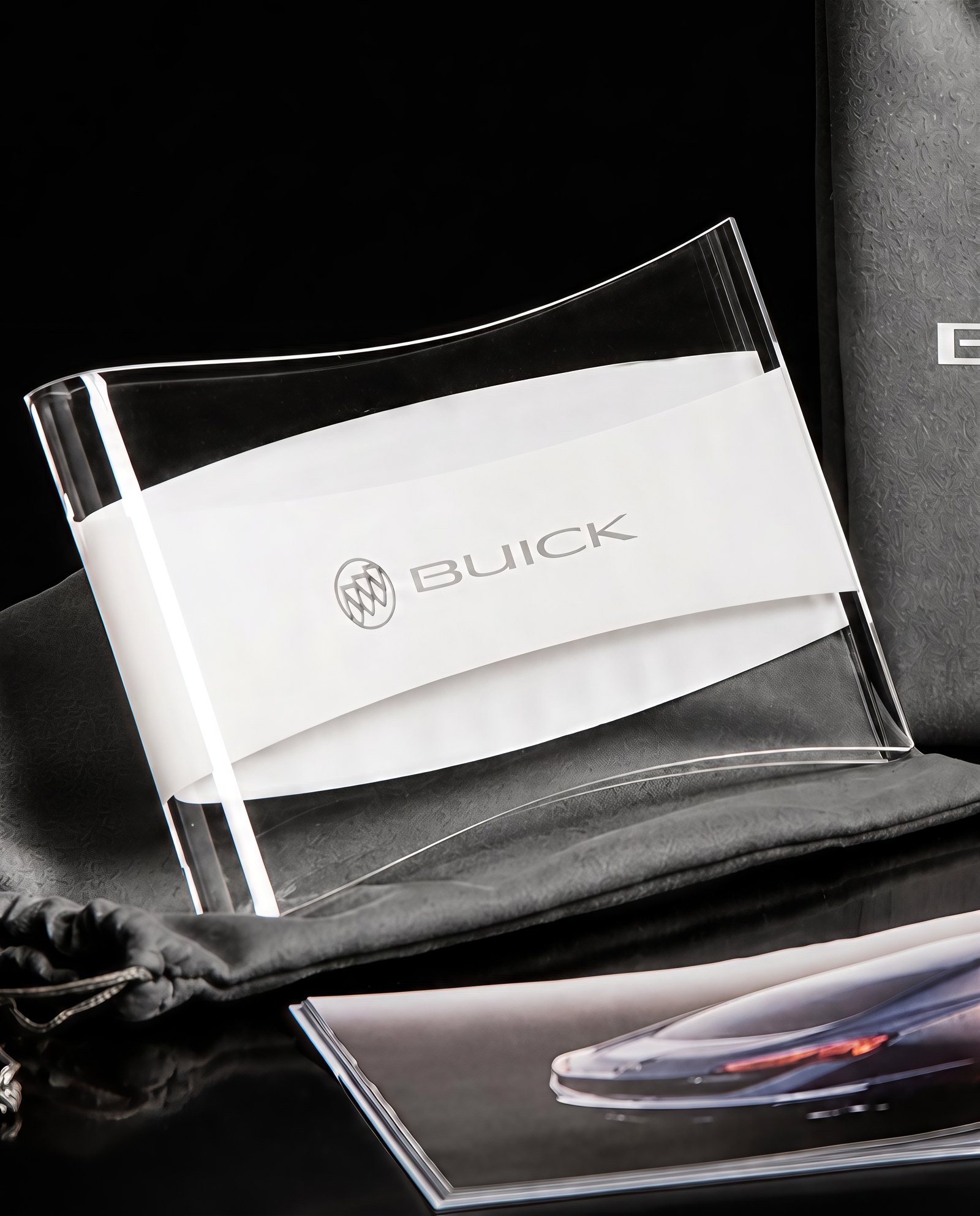 The etched lucite sleeve resting on the silk-screened felt pouch, photographed in low light